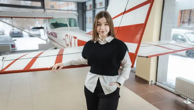 Aleksandra Abraite standing next to airplane