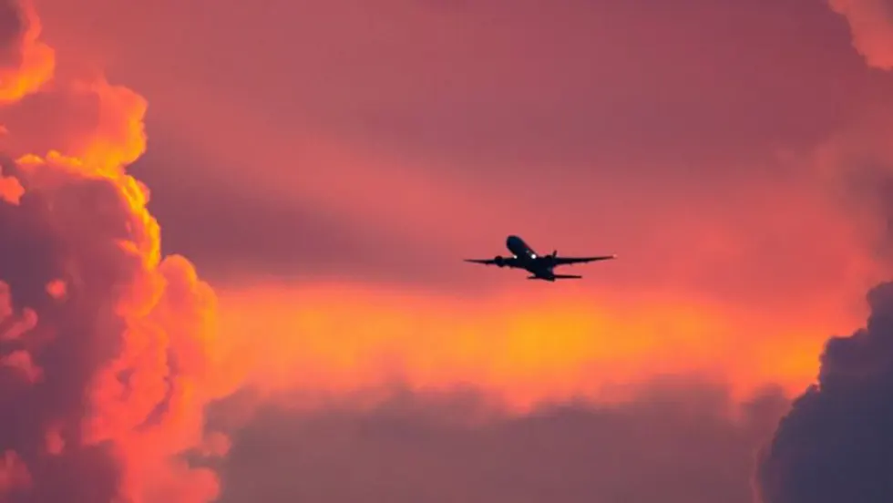 Lidmašīna paceļas uz sarkana debesu fona